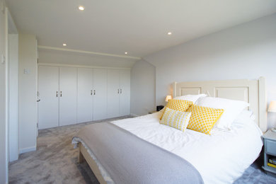 Foto di una camera matrimoniale minimalista di medie dimensioni con pareti grigie, moquette e pavimento grigio