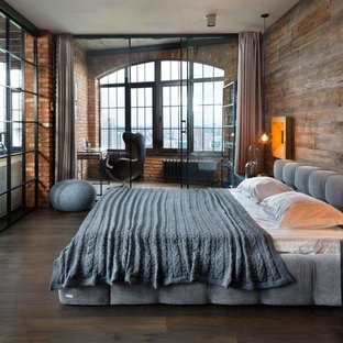 Esempio di una camera da letto industriale con parquet scuro