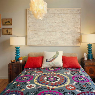 Example of an eclectic medium tone wood floor bedroom design in New York with beige walls