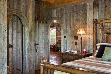 Imagen de dormitorio principal clásico de tamaño medio sin chimenea con paredes marrones, suelo de madera en tonos medios y suelo marrón