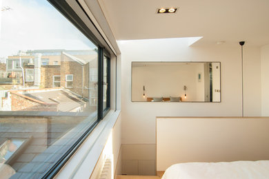 ロンドンにある小さな北欧スタイルのおしゃれな客用寝室 (白い壁、淡色無垢フローリング) のレイアウト