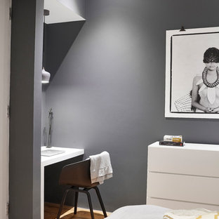 Design ideas for an urban guest bedroom in London with grey walls, medium hardwood flooring and brown floors.