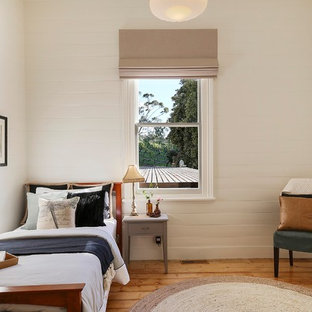 Design ideas for a transitional bedroom in Geelong with white walls, medium hardwood floors and brown floor.
