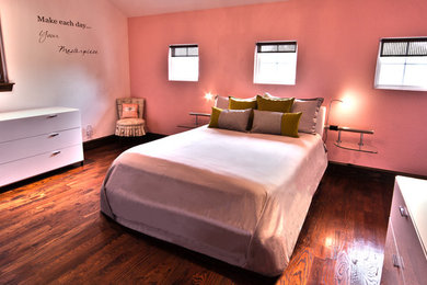 Mid-sized trendy medium tone wood floor bedroom photo in Dallas with pink walls