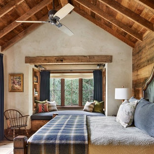 Immagine di una camera matrimoniale stile rurale con pareti beige, nessun camino e parquet chiaro