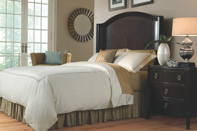 Example of a mid-sized classic master medium tone wood floor bedroom design in St Louis with beige walls and no fireplace