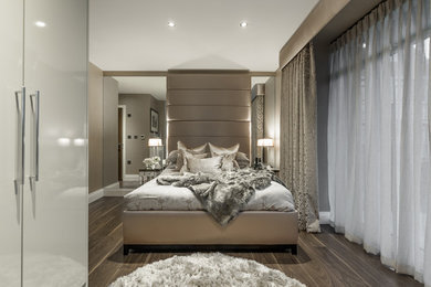 Example of a mid-sized trendy master laminate floor and brown floor bedroom design in Hertfordshire with brown walls and no fireplace