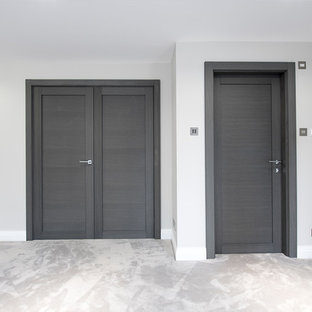 Modelo de habitación de invitados minimalista, grande, con paredes blancas, moqueta y suelo beige