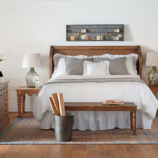 Country master bedroom in Houston with white walls, medium hardwood flooring and no fireplace.