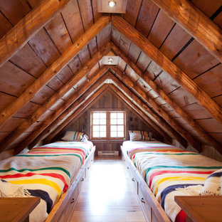 Example of a mid-sized mountain style guest medium tone wood floor bedroom design in Other with brown walls and no fireplace