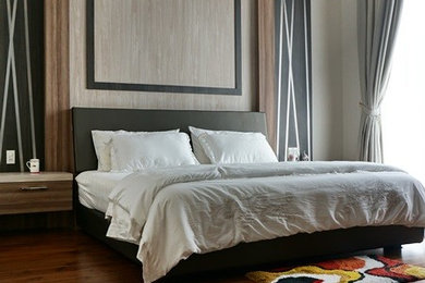 Imagen de dormitorio principal exótico de tamaño medio sin chimenea con paredes multicolor y suelo de madera en tonos medios
