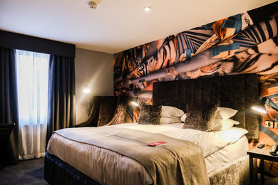Inspiration for a contemporary bedroom in Belfast with multi-coloured walls, carpet, no fireplace and grey floors.