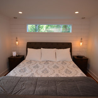 Modelo de dormitorio principal, de estilo americano, de tamaño medio, con paredes blancas, suelo de bambú y suelo rojo