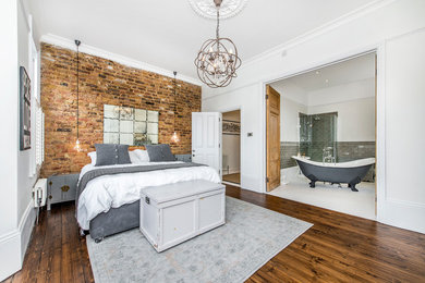 Design ideas for a rustic master bedroom in London with white walls and medium hardwood flooring.
