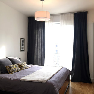 Modelo de dormitorio principal, nórdico, con paredes blancas, suelo de corcho, chimenea lineal y marco de chimenea de hormigón
