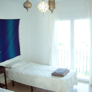 Foto de habitación de invitados tropical, pequeña, sin chimenea, con paredes blancas