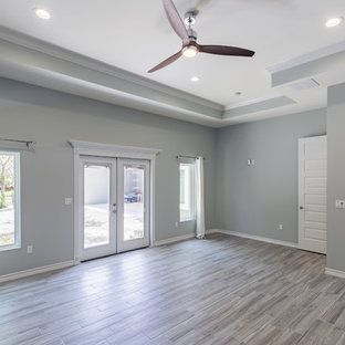 Example of a large beach style master porcelain tile bedroom design in Austin with gray walls and no fireplace