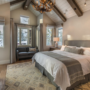 Mittelgroßes Uriges Hauptschlafzimmer mit beiger Wandfarbe, braunem Holzboden, Kamin, Kaminumrandung aus Stein und braunem Boden in Sacramento
