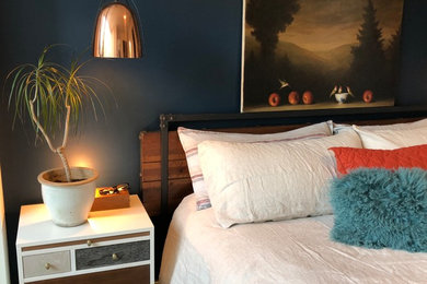 Imagen de dormitorio principal actual de tamaño medio con paredes azules, suelo de madera oscura y suelo marrón