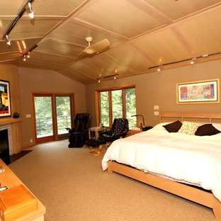 Diseño de dormitorio principal, actual, grande, con chimenea tradicional, marco de chimenea de baldosas y/o azulejos, paredes beige y moqueta