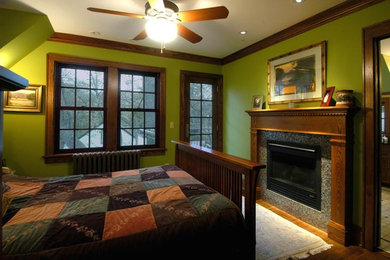 ミネアポリスにある中くらいなコンテンポラリースタイルのおしゃれな主寝室 (緑の壁、淡色無垢フローリング、標準型暖炉、石材の暖炉まわり) のインテリア