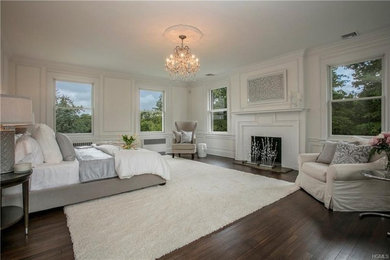 ニューヨークにあるトランジショナルスタイルのおしゃれな寝室 (白い壁、濃色無垢フローリング、標準型暖炉、レンガの暖炉まわり、茶色い床) のレイアウト