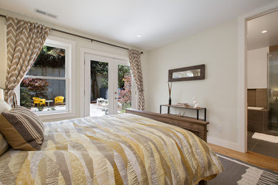 Imagen de dormitorio principal bohemio de tamaño medio con paredes grises, suelo de madera en tonos medios y suelo marrón