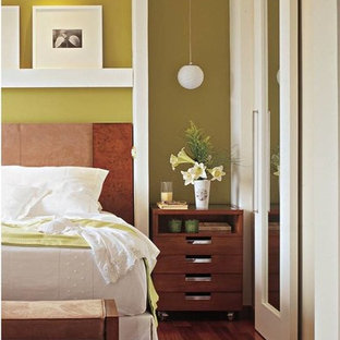 Modelo de dormitorio principal, contemporáneo, de tamaño medio, con paredes verdes y suelo de madera en tonos medios