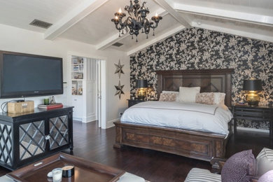 Large coastal master bedroom in Los Angeles with dark hardwood flooring and brown floors.