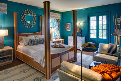 Imagen de dormitorio principal actual de tamaño medio sin chimenea con paredes verdes y suelo de madera en tonos medios