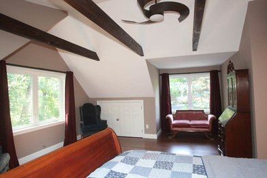 Imagen de dormitorio principal tradicional con paredes beige, suelo de madera en tonos medios y suelo marrón