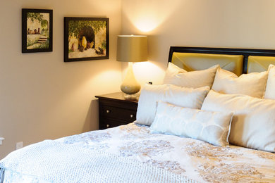 Imagen de dormitorio principal clásico renovado grande sin chimenea con paredes beige, suelo de madera clara y suelo beige