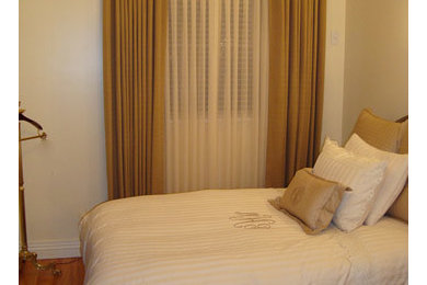 Ejemplo de dormitorio principal actual de tamaño medio sin chimenea con paredes beige y suelo de madera en tonos medios