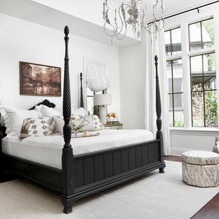 This is an example of a traditional master bedroom in Nashville with white walls, dark hardwood flooring and no fireplace.