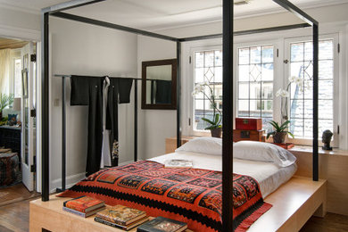 Modelo de dormitorio principal con suelo de madera oscura y suelo marrón