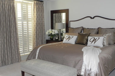 Modelo de dormitorio principal clásico renovado grande con paredes beige y moqueta