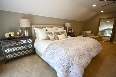 Ejemplo de dormitorio principal actual de tamaño medio con paredes beige, moqueta, chimenea de esquina, marco de chimenea de piedra y suelo beige