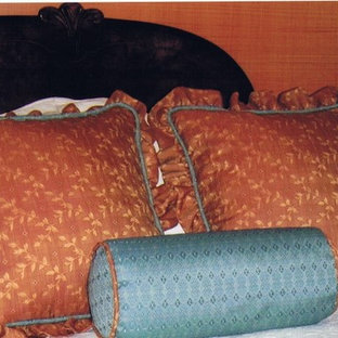Modelo de dormitorio principal, tradicional, de tamaño medio, con suelo de madera oscura, chimenea lineal y marco de chimenea de madera