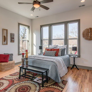 Idée de décoration pour une chambre parentale craftsman de taille moyenne avec un mur blanc et un sol en bois clair.