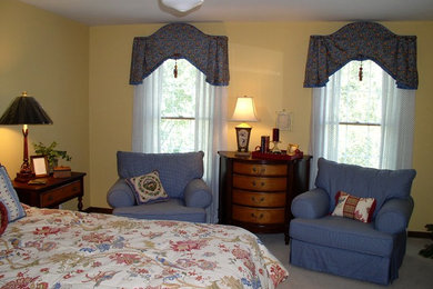 Example of a mid-sized tuscan master carpeted bedroom design in St Louis with yellow walls and no fireplace