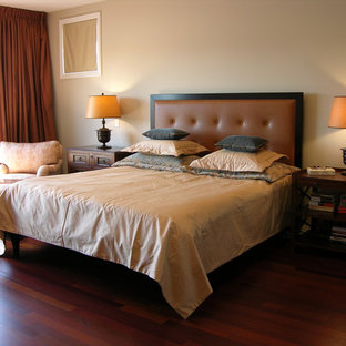 Imagen de dormitorio principal, clásico renovado, con paredes beige, suelo de madera oscura y suelo rojo