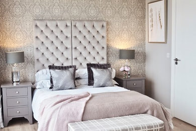 Foto de dormitorio principal clásico renovado de tamaño medio sin chimenea con paredes grises, suelo laminado y suelo beige
