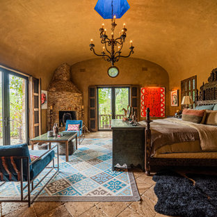 Ejemplo de dormitorio principal y abovedado, de estilo americano, con paredes marrones, chimenea de esquina, marco de chimenea de piedra y suelo marrón