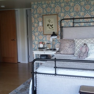 Diseño de dormitorio principal, tradicional, grande, con paredes blancas, suelo de madera clara, chimenea tradicional, marco de chimenea de ladrillo y suelo beige