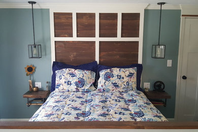 Modelo de dormitorio principal industrial de tamaño medio sin chimenea con paredes azules y moqueta