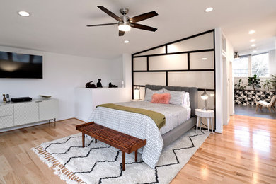 На фото: хозяйская спальня среднего размера в стиле ретро с белыми стенами, деревянным полом и разноцветным полом без камина с
