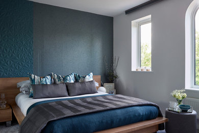 Design ideas for a modern master bedroom in Essex with blue walls, carpet and grey floors.
