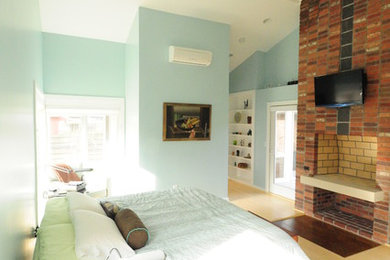 Réalisation d'une chambre parentale design de taille moyenne avec un mur bleu, parquet clair, un manteau de cheminée en brique, une cheminée standard et un sol beige.