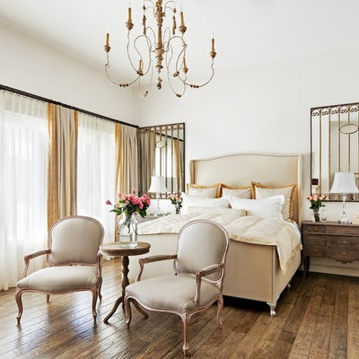Elegant medium tone wood floor and brown floor bedroom photo in Phoenix with white walls