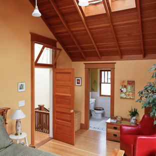 Foto de dormitorio principal, de estilo americano, extra grande, con paredes amarillas y suelo de madera clara